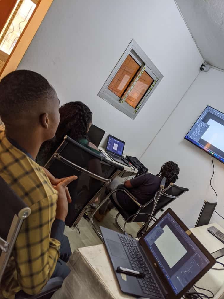 Séance de cours particulier en informatique chez Merlo Skills Group, formateur et apprenants devant plusieurs ordinateurs portables.