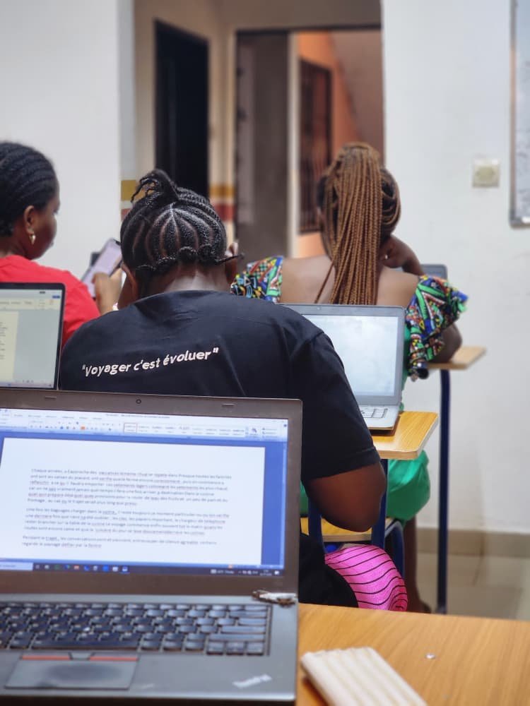 Salle de formation informatique de Merlo Skills Group, apprenants sur ordinateur portable en exercice pratique.