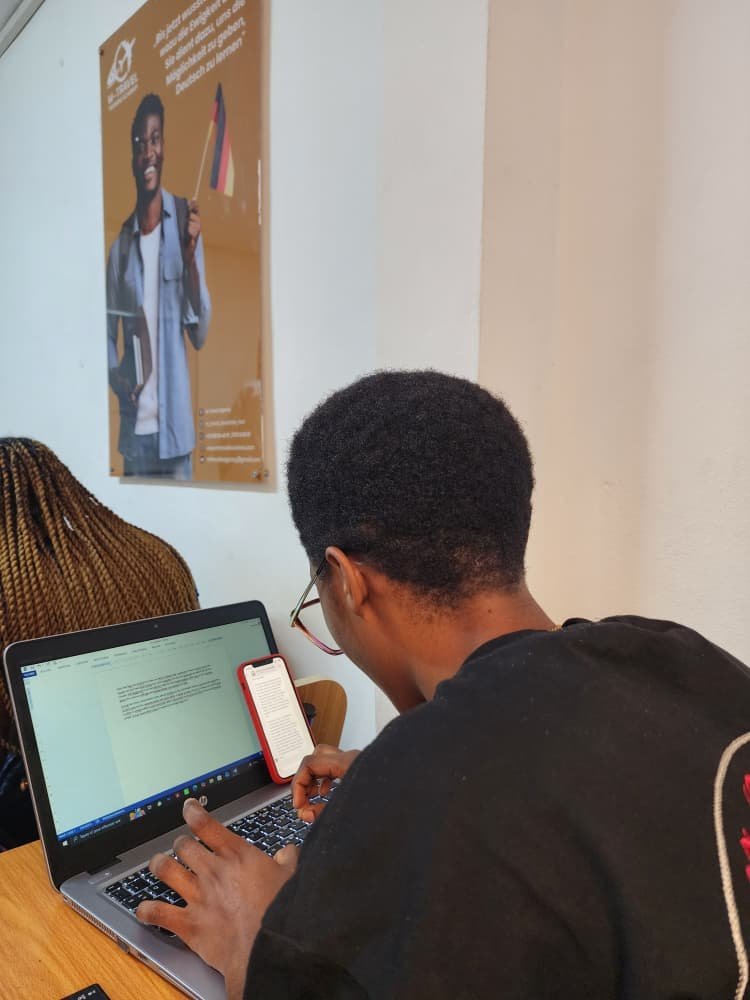 Apprenant en préparation à l'examen TELC d'allemand, travaillant sur ordinateur portable chez Merlo Skills Group.